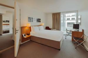 um quarto de hotel com uma cama e uma secretária com um computador em DoubleTree by Hilton Hotel London - Tower of London em Londres