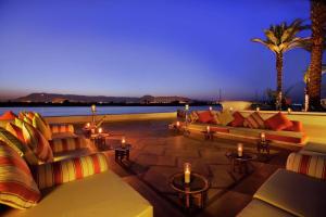 une terrasse avec des canapés et des bougies ainsi qu'une piscine dans l'établissement Hilton Luxor Resort & Spa, à Louxor
