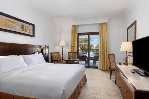 una camera d'albergo con letto e TV di Hilton Luxor Resort & Spa a Luxor