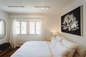 a bedroom with a white bed and a window at Romantic JUMP Studio overlooking river, free parking in Ljubljana