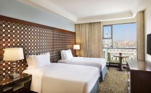 a hotel room with two beds and a window at Hilton Suites Makkah in Makkah