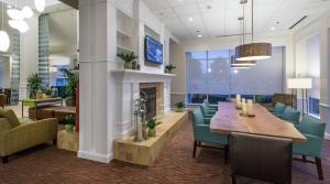 a dining room with a table and chairs and a fireplace at Hilton Garden Inn Macon/Mercer University in Macon