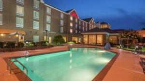 uma piscina em frente a um hotel à noite em Hilton Garden Inn Macon/Mercer University em Macon