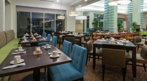 a restaurant with wooden tables and blue chairs at Hilton Garden Inn Macon/Mercer University in Macon