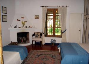 1 dormitorio con 2 camas, chimenea y ventana en Estancia Aguila Blanca, en Polanco