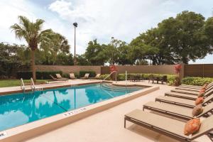 uma piscina com espreguiçadeiras ao lado de um resort em Embassy Suites by Hilton Orlando International Drive ICON Park em Orlando