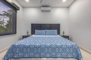 a bedroom with a bed with a blue comforter at Casamar Villa's in Uvita +38 photos