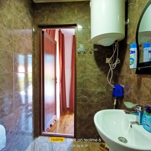 a bathroom with a sink and a mirror at B&B House in Mestia