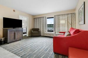 a living room with a red couch and a flat screen tv at Hampton Inn & Suites Memphis-Wolfchase Galleria in Memphis