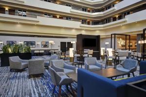a hotel lobby with chairs and a flat screen tv at Embassy Suites Montgomery - Hotel & Conference Center in Montgomery