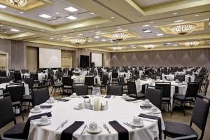 a large banquet room with tables and chairs and a podium at Embassy Suites Montgomery - Hotel & Conference Center in Montgomery +73 photos
