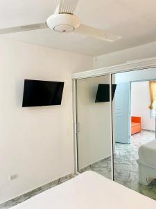 een slaapkamer met een flatscreen-tv aan de muur bij Apartamentos felix Las terrenas in Las Terrenas