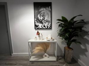 a table with a plant and a picture on the wall at Artistic Apartment in Riyadh in Riyadh