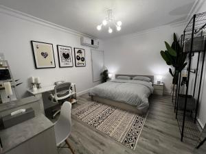a white bedroom with a bed and a desk and a desk at Artistic Apartment in Riyadh in Riyadh