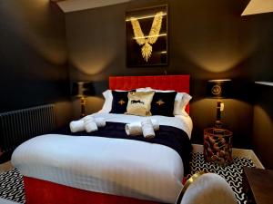 Schlafzimmer mit einem großen Bett mit einem roten Kopfteil in der Unterkunft The Hamilton - The Studio luxury holiday let's in Scorton
