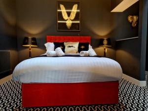 1 cama roja en una habitación con 2 lámparas en The Hamilton - The Studio luxury holiday let's, en Scorton