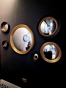 4 miroirs circulaires sur un mur noir dans une pièce dans l'établissement The Hamilton - The Studio luxury holiday let's, à Scorton