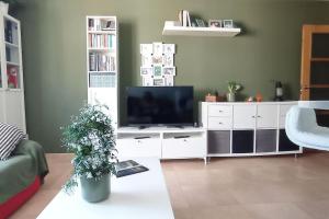 a living room with a television on a white entertainment center at Apartamento Cee - Costa da Morte in Cee