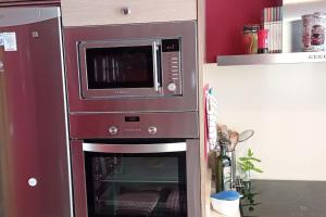 a microwave and an oven in a kitchen at Apartamento Cee - Costa da Morte in Cee