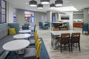 una sala de espera con mesas y sillas en Hampton Inn & Suites Miami-Doral Dolphin Mall, en Miami