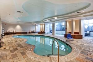 a large swimming pool in a hotel lobby at Embassy Suites by Hilton Minneapolis Airport in Bloomington