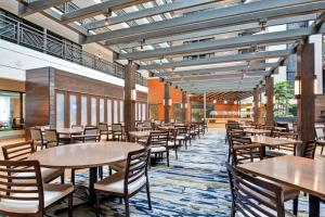 a dining area with tables and chairs in a building at Embassy Suites by Hilton Minneapolis Airport in Bloomington