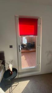 a door to a living room with a red curtain at large room with garden area with direct access onto beach in Fife