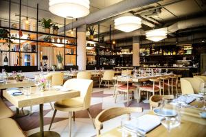 un ristorante con tavoli e sedie e un bar di Hilton Munich City a Monaco