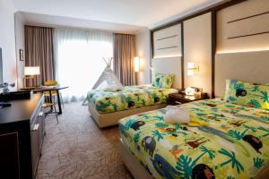 a hotel room with two beds and a desk at Hilton Munich City in Munich