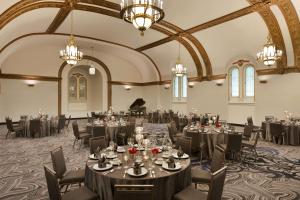 a banquet hall with tables and chairs and a piano at Hilton New Orleans / St. Charles Avenue in New Orleans