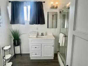 a bathroom with a white sink and a shower at Glendora Pool Home Retreat in Glendora +14 photos