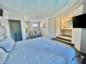 a bedroom with a large white bed and a couch at Glendora Pool Home Retreat in Glendora