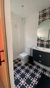 a bathroom with a toilet and a sink and a mirror at large room with garden area with direct access onto beach in Fife
