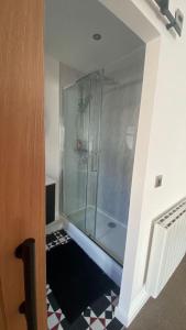 a glass shower in a room with a tile floor at large room with garden area with direct access onto beach in Fife