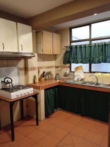 a kitchen with a stove and a sink at Tin House Quito in Quito