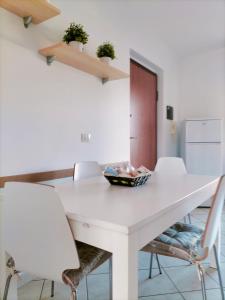 Appartamento Solaris 200 m dal mare في سان سالفو: طاولة غرفة طعام بيضاء مع كراسي بيضاء