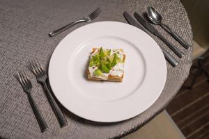 a white plate with a piece of food on a table at Conrad New York Downtown in New York