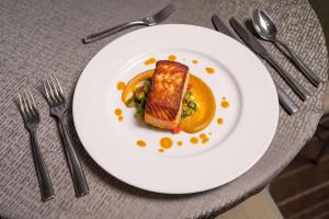 a white plate with a sandwich on a table with silverware at Conrad New York Downtown in New York
