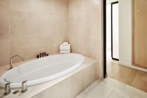 a white bath tub in a bathroom with a window at Conrad New York Downtown in New York