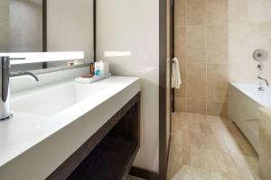 a bathroom with a sink and a tub and a toilet at Conrad New York Downtown in New York