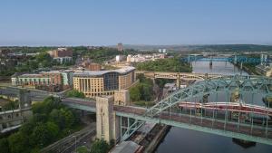 un puente sobre un río con un tren en él en Hilton Newcastle Gateshead, en Newcastle