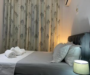 - un lit avec des oreillers blancs et un rideau dans l'établissement Cosy, private apartment in a family villa, à Tirana