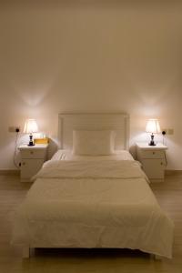 a bedroom with a white bed with two lamps on tables at دور أرضي بتصميم فاخر دخول ذاتي in Riyadh