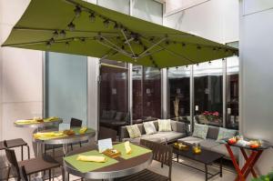 un patio con mesas y una sombrilla verde en Hilton Garden Inn New York Manhattan Midtown East, en Nueva York