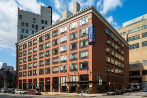 a large red brick building with a sign on it at Hilton Garden Inn New York/Tribeca in New York