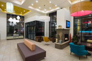 eine Lobby mit einem Sofa, Stühlen und einem Kamin in der Unterkunft Hilton Garden Inn New York/Tribeca in New York