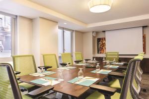 een vergaderzaal met een lange tafel en groene stoelen bij Hilton Garden Inn New York Manhattan Midtown East in New York