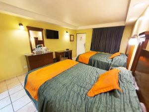 NogalesにあるHotel Marques de Cimaのベッドが2つと鏡があるホテルの部屋