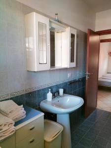 bagno con lavandino bianco e specchio di Appartamento Solaris 200 m dal mare a San Salvo