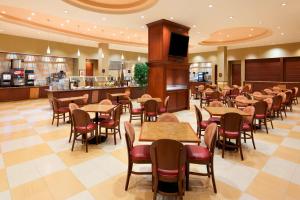 a restaurant with tables and chairs and a bar at Embassy Suites by Hilton Norman Hotel & Conference Center in Norman